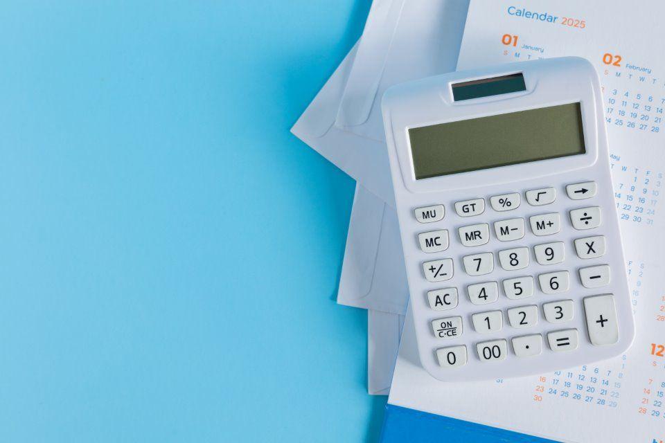 Image of a calculator on a stack of bookkeeping documents